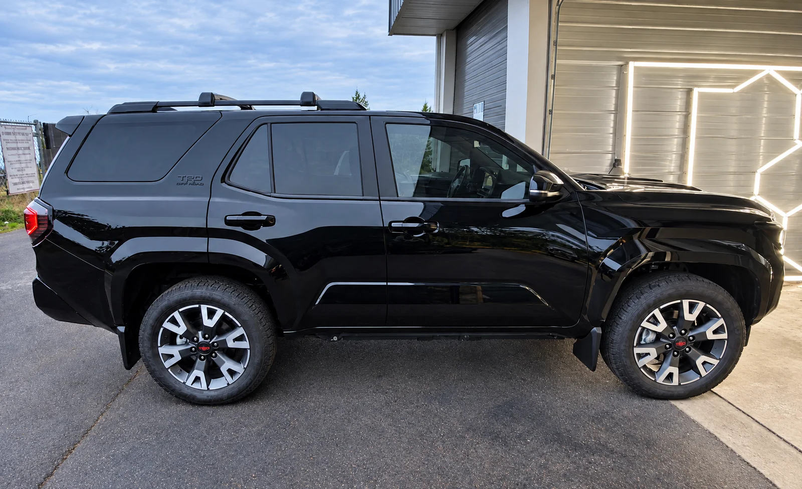 A black Toyota 4Runner with tinted windows outside the T.I.N.T bay