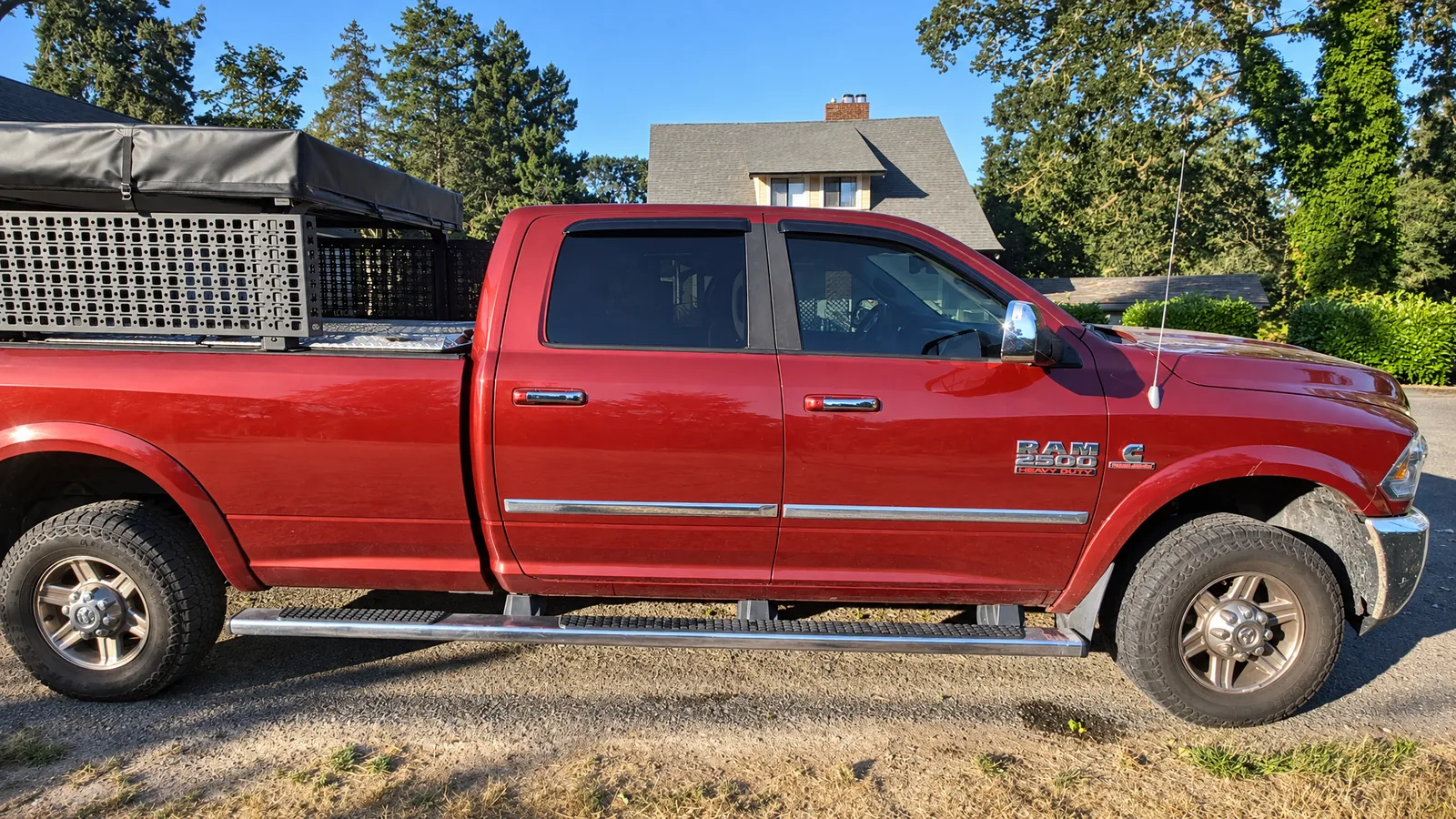 A red Ram 2500 truck with tinted windows, finished on the customer’s driveway